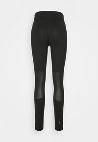 Leggings neri con vita alta, caratterizzati da pannelli in rete nella parte inferiore delle gambe e sottili dettagli a forma di stella vicino all'orlo. Texture liscia su tutta la superficie.