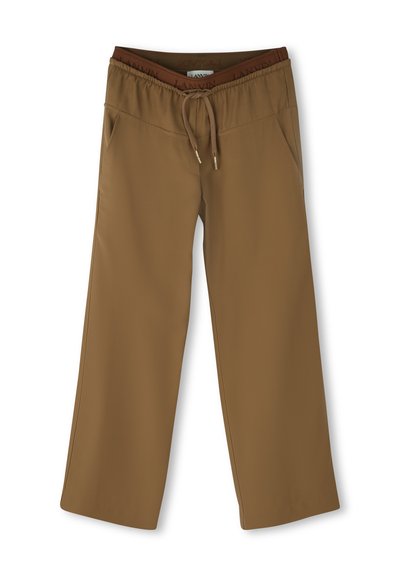 Bruine wijde broek met elastische tailleband, trekkoord en zijzakken, plat op een witte achtergrond gelegd.