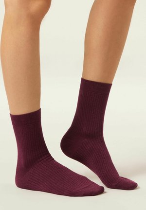 Burgundy ribbade strumpor i mjukt tyg, med en design i ankellängd och en slät yta med subtil glans.