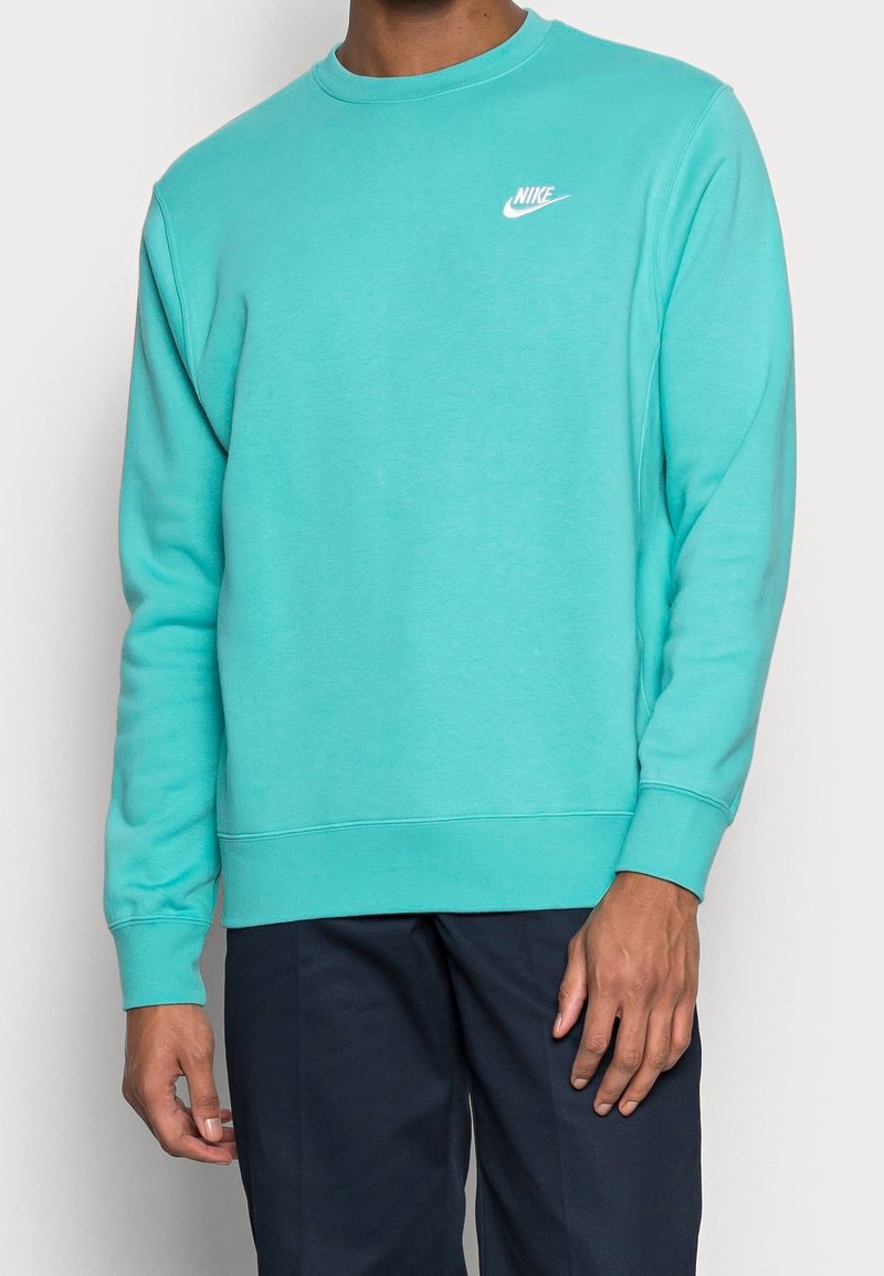 Turkos crewneck sweatshirt i mjukt tyg. Har en vit Nike-logga på bröstet och ribbade muddar och nederkant.