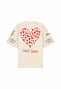Maglietta beige con cuore rosso composto da cuori più piccoli e testo "SWEET heart" sulla schiena, maniche decorate con cuori e fiori.