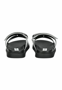Sandali piatti neri con cinturini in argento, caratterizzati da un design semplice e una soletta imbottita. Stile facile da indossare con cinturini regolabili alla caviglia.