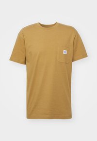 T-shirt à manches courtes, couleur jaune moutarde, en coton, avec une poche poitrine dotée d'une petite étiquette et un col rond.
