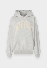 Grå hoodie lavet af bomuldsblandingsstof. Har et stort "HEARTBEAT" logo broderet i lys fløde. Kænguru lomme og ribbede manchetter.