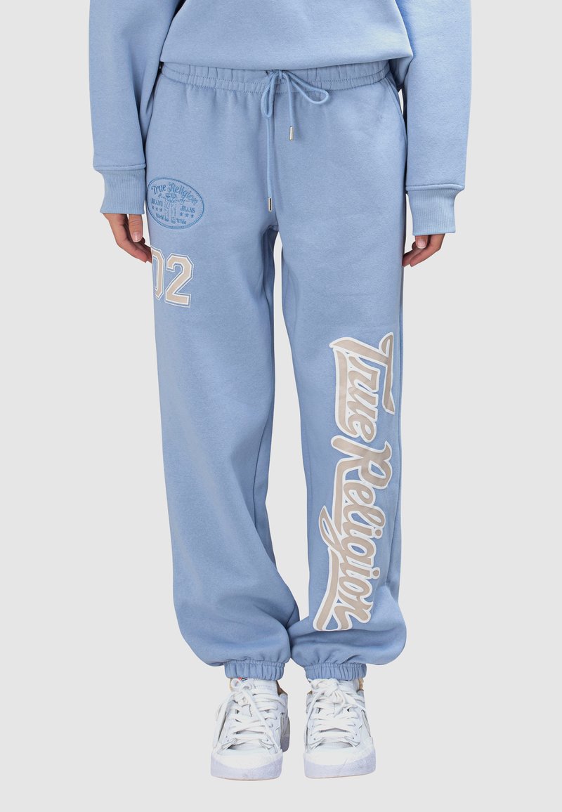 Hellblaue Sweatpants aus Baumwolle mit elastischem Bund. Auf der Seite befinden sich das "True Religion"-Logo und die Zahl "02" in Cremefarbe gedruckt.