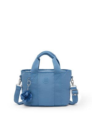 Bolso pequeño de tela azul con asas cortas, correa de hombro ajustable y un llavero de mono de peluche sujeto al frente.