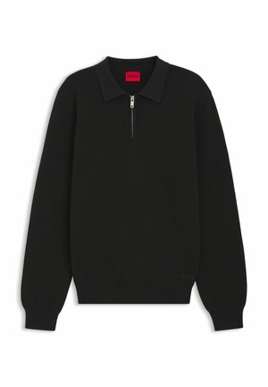 Svart zip-up tröja med polo-krage, ribbat mönster, långa ärmar och subtil märkning vid fållen. Materialet verkar vara stickat och hållbart.