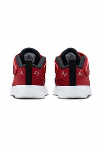 Czerwone sportowe buty z teksturowaną cholewką, z wyprofilowaną kołnierz, białą podeszwą i czarnymi akcentami. Zawierają pętlę do zakupu i haftowany detal z numerem "23".