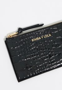 Bolsito de cuero sintético negro con textura de cocodrilo, cremallera dorada y logotipo "BIMBA Y LOLA" en impresión metálica. Acabado suave, diseño compacto.