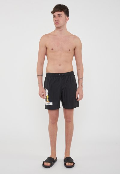 Pantaloni da nuoto neri realizzati in tessuto leggero, con una grafica di cartone animato sulla gamba sinistra. Include una vita elastica e un cordino.