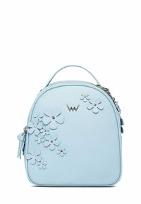 Světlomodrá kabelka s horním držadlem, květinovými aplikacemi se stříbrnými nýty na přední straně, zapínáním na zip a malým kovovým logem poblíž horního středu.