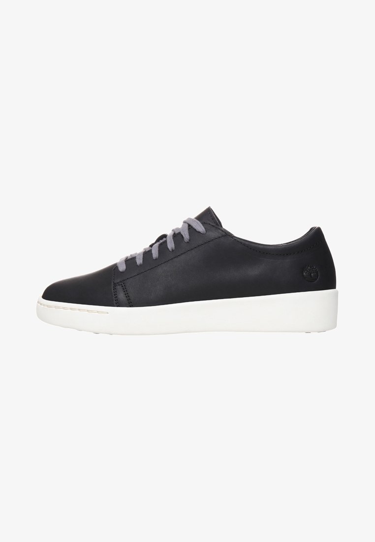 Baskets basses en cuir noir avec lacets gris et semelle blanche épaisse, montrées de profil sur fond blanc.