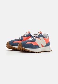 Marineblaue Wildledersneaker mit korallenrot- und cremfarbenen Akzenten, Gummisohle, abgerundeter Zehenform und kontrastierenden Schnürsenkelösen. Minimalistisches Design.