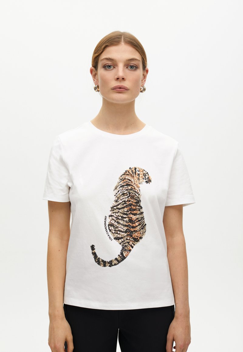 White cotton t-shirt featuring a sequin-embellished tiger graphic in orange, brown, and black, with short sleeves and a round neckline.
