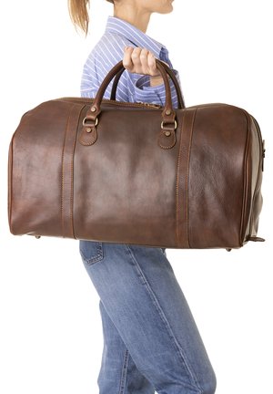 Sac de voyage en cuir marron avec des poignées solides, finition texturée et surpiqûres contrastantes. Comprend une fermeture éclair et une forme arrondie.