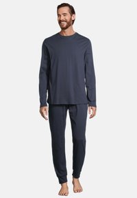Haut à manches longues bleu marine et pantalon assorti, fabriqués en tissu doux avec des poignets élastiques. Design simple avec un col rond, sans motifs visibles.
