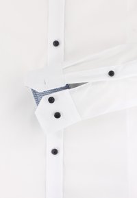 Witte overhemden met een blauw patroon in de manchetten. Voorzien van zwarte knopen en een klassieke kraag. Glad stof met een getailleerde pasvorm.
