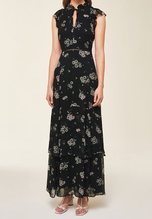 Robe maxi noire à motifs floraux avec des manches courtes à volants, un décolleté en trou de serrure, et des couches en volants. Présente un motif floral dans des couleurs claires.