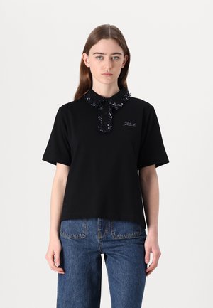 Must värvi lühikeste varrukatega polo särk tekstureeritud kraega, millel on riba detail. Vasakul küljel tikitud logo, kombineeritud denimist teksadega.