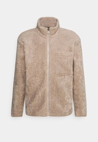 Beige fleecejakke med høj krave, fuld lynlås og en brystlomme. Tekstureret stof med et blødt, fyldigt udseende.