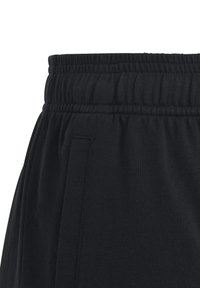 Pantalones de chándal negros con cinturilla elástica, bolsillos laterales y una tela suave y texturizada con detalles de costura visibles.