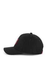 Casquette de baseball noire avec une visière incurvée, présentant un patch logo rouge sur le côté. Matériau en coton avec une texture lisse et des trous de ventilation sur les côtés.
