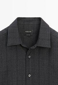 Mørkegrå skjorte med knapper og spidse krave, to synlige knapper og "Massimo Dutti"-mærke indeni halsudskæringen.