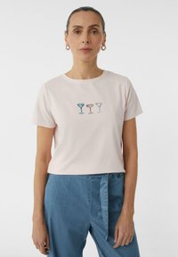 Light pink cotton t-shirt featuring three embroidered cocktail glasses in blue, pink, and beige at the center. Short sleeves and round neck.