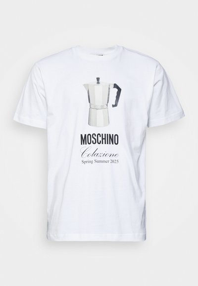 T-shirt en coton blanc avec un graphique d'une cafetière moka argentée et un texte noir indiquant "MOSCHINO Colazione Printemps Été 2025" en dessous.
