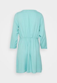 Vestido em água-marinha com mangas longas, cintura franzida, textura suave e decote redondo. Design simples sem padrões visíveis ou adornos.