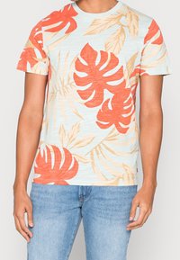 Kurzarmhemd in hellblau mit rotem tropischem Blättermuster; weicher Stoff mit lockerer Passform; runder Ausschnitt; lässiger Stil.