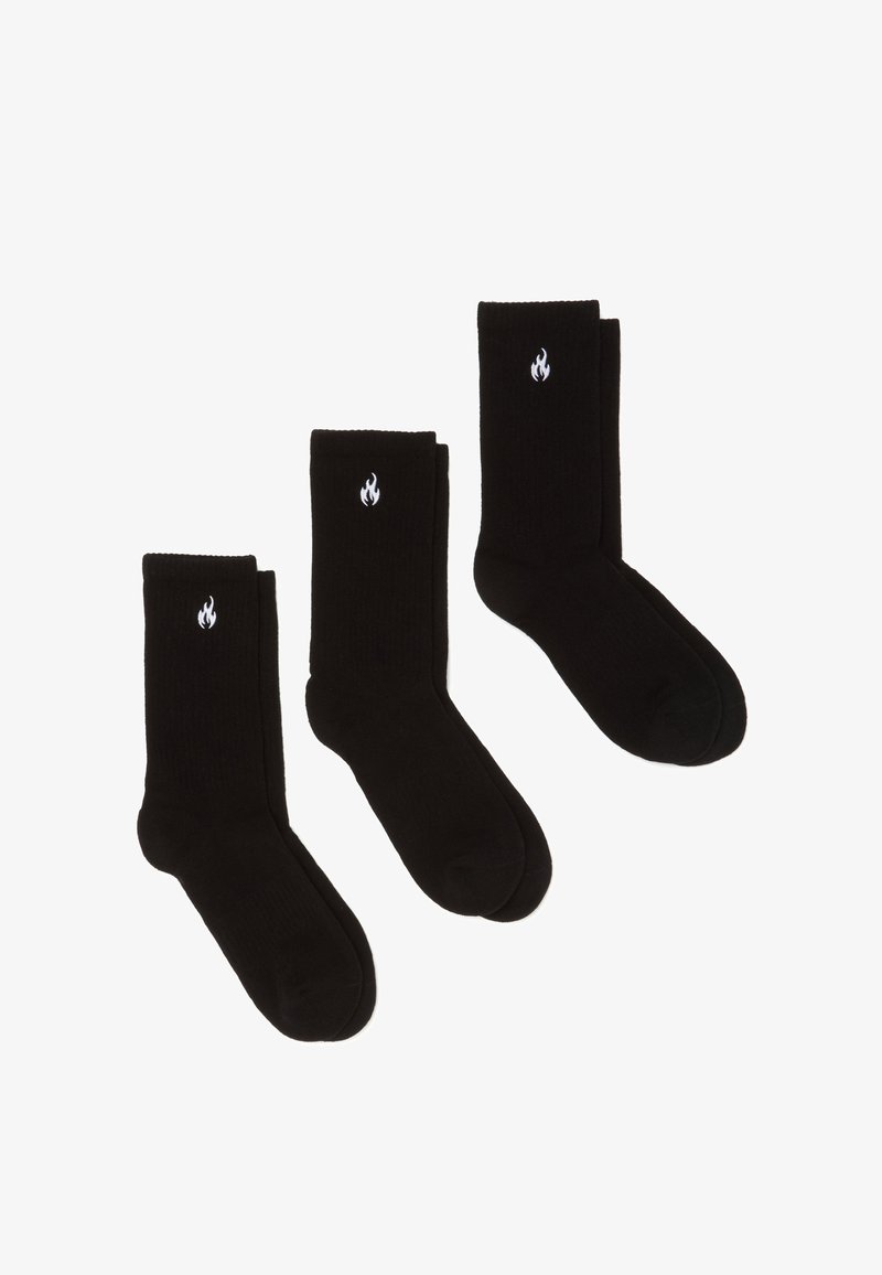 Tres pares de calcetines de algodón negro con puños acanalados, que presentan un pequeño logo de llama blanca en cada calcetín. Textura suave y diseño de altura estándar.
