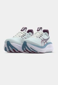 Světlomodré sportovní boty s texturovaným svrškem, bílou stélkou a tyrkysovými akcenty. Mají fialové detaily na patě a jazyku; šněrovací design.