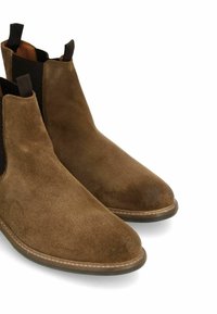 Bottines Chelsea en suede marron avec panneaux latéraux élastiques et languettes en cuir, présentant un bout arrondi et une semelle en caoutchouc durable.