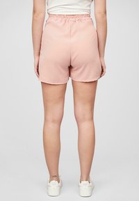 Shorts rose clair avec une taille élastique, fabriqués dans un tissu doux. Présentent une coupe décontractée et un ourlet légèrement courbé au niveau des jambes.