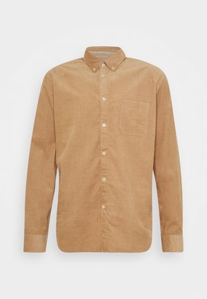 Bruine ribfluwelen shirt met lange mouwen, knoopsluiting, borstzak en lichtgekleurde knopen. Geweven stof met verticale ribbels.