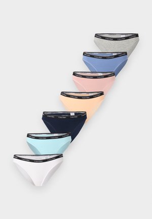Έξι μπικίνι εσώρουχα Calvin Klein σε γκρι, μπλε, ροζ, ροδακινί, ναυτικό, ανοιχτό μπλε και λευκό, με μαύρες ζώνες στη μέση με επώνυμο λογότυπο, τοποθετημένα διαγώνια σε γκρι φόντο.