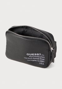 Schwarze, strukturiert genähte Leder-Pouch mit silbernem Reißverschluss, versehen mit weißen, bedruckten Markendetails und einer rechteckigen Form.