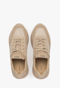 Beige sneakers van mesh en suede materiaal, ronde neus, vetersluiting, gevoerd kraagje en logo op de tong voor branding.