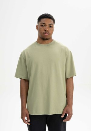 Short-sleeve, crew neck t-shirt in light green cotton material. Relaxed fit with straight hem and undefined shoulders. Subtle texture.