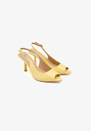 Escarpins jaunes à bout ouvert avec bride arrière réglable à la cheville et talons moyens fins sur fond blanc.