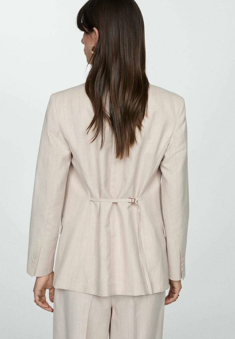 Helle beige maßgeschneiderte Blazerjacke mit horizontalen Streifen, Ein-Knopf-Verschluss und Taillierung. Strukturierter Stoff, lange Ärmel.