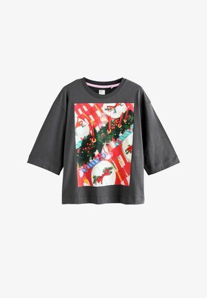 Harmaa lyhythihainen t-paita, jossa on värikäs painatus juhlavasta ruokapöydästä, johon kuuluu lautasia, kynttilöitä ja joulukoristeita.