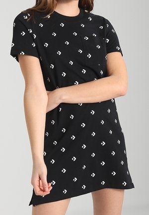 Black short-sleeve dress featuring a pocket, adorned with white star and arrow patterns, soft fabric, straight cut, and rounded neckline.