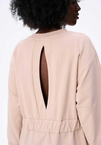 Helles rosa Langarmkleid mit lockerer Passform, das hinten eine Schlüsselöffnungsdetails und einen elastischen Taillenbund für zusätzlichen Komfort aufweist.