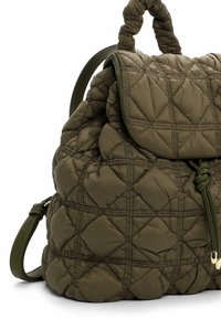 Sac à dos matelassé vert olive avec un rabat repliable, des accents noués et des bretelles réglables. Texture lisse avec un motif en diamant.