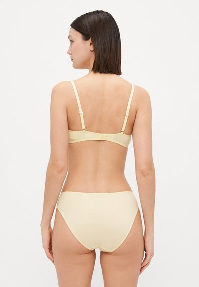Yellow cotton bra and panty set, featuring adjustable straps, scalloped edges, and a smooth texture, viewed from the back.