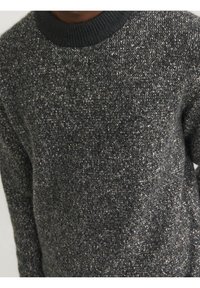 Maglione lavorato a maglia grigio scuro con colletto nero a coste arrotondato, caratterizzato da un motivo maculato e maniche lunghe.