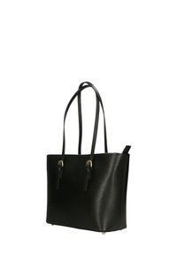 Zwarte leren tote bag met twee lange handvatten, een gladde textuur, goudkleurige hardware-accenten en vier beschermende voeten aan de onderkant.