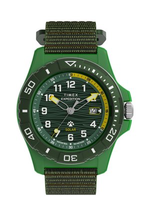 Vihreä Timex Expedition -aurinkokello kangashihnalla, pyörivällä kehyksellä, päivämääränäyttö kello 3 kohdalla ja vedenpitävyys 50 metriin asti.
